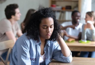Upset mixed race woman offended by friends, feeling unhappy Upset mixed race woman offended by friends, feeling unhappy